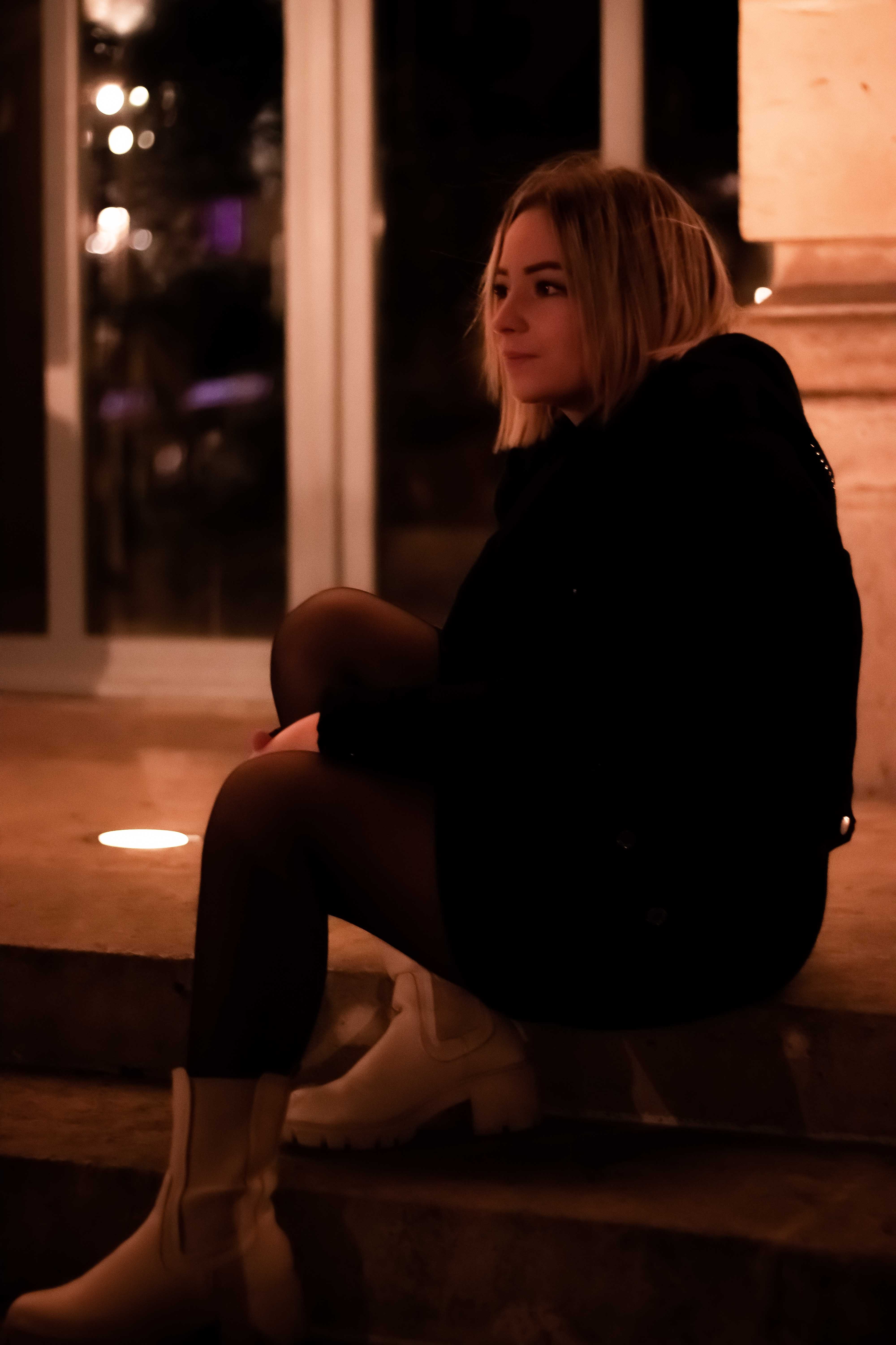 Photo d'une jeune femme vu de coté assise sur un escalier